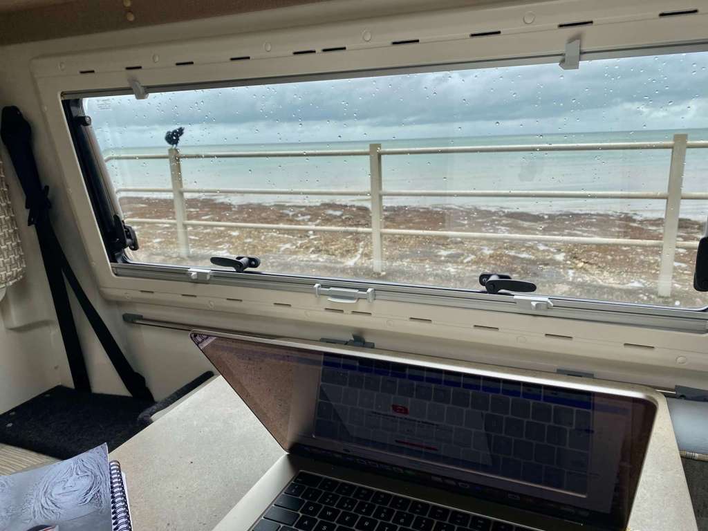 A coastal view taken from inside a camper van.